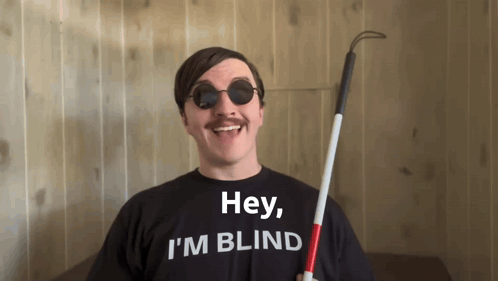 A Man Wearing Sunglasses And A Black Shirt That Says Hey I 'M Blind GIF