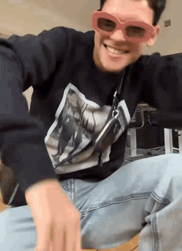 A Man Wearing Sunglasses And A Black Shirt With A Picture On It GIF