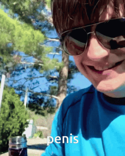 A Man Wearing Sunglasses And A Blue Shirt Has The Word Penis Written On His Shirt GIF