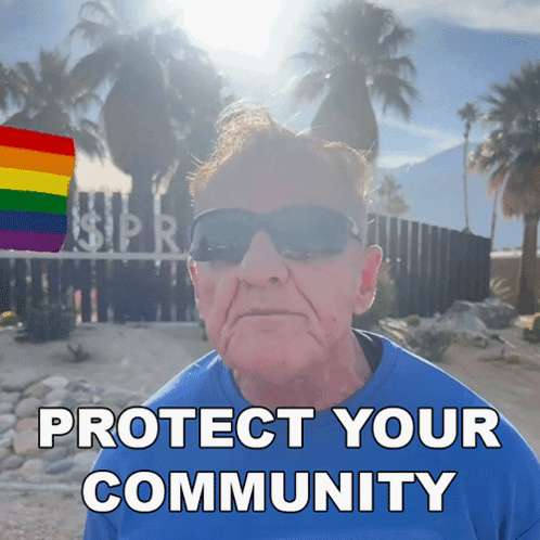A Man Wearing Sunglasses And A Blue Shirt Stands In Front Of A Sign That Says " Protect Your Community " GIF