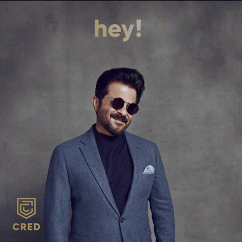 A Man Wearing Sunglasses And A Blue Suit Is Standing In Front Of A Sign That Says " Hey " GIF