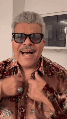 A Man Wearing Sunglasses And A Floral Shirt Laughs GIF