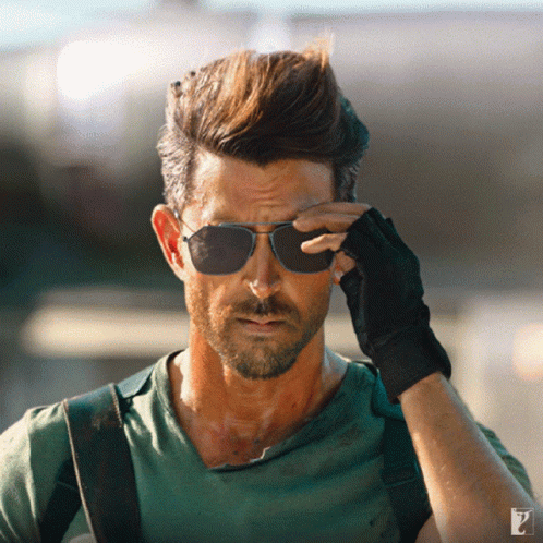 A Man Wearing Sunglasses And A Green Shirt Has The Letter P On The Bottom Right GIF