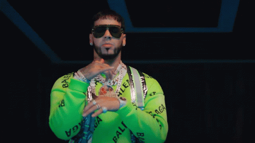 A Man Wearing Sunglasses And A Green Sweater With The Word Balenciaga On It GIF