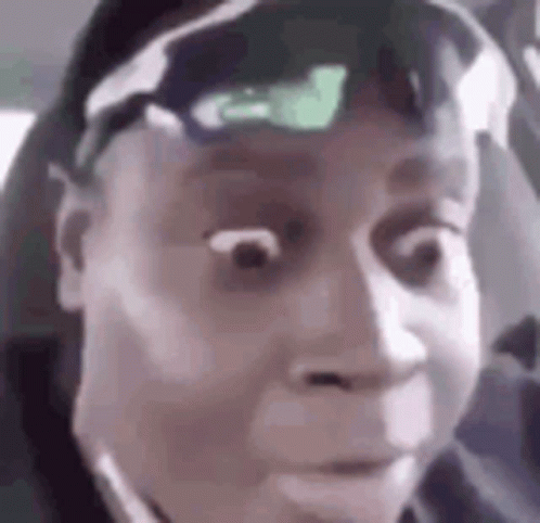 A Man Wearing Sunglasses And A Hat Is Making A Funny Face In A Car . GIF