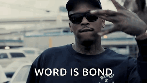 A Man Wearing Sunglasses And A Hat Is Making A Peace Sign And The Words Word Is Bond Are Visible . GIF