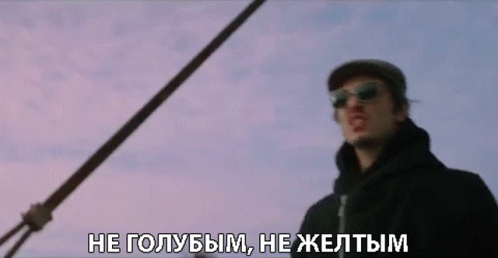 A Man Wearing Sunglasses And A Hat Is Standing In Front Of A Purple Sky GIF
