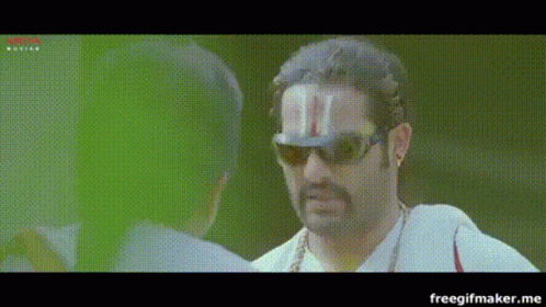 A Man Wearing Sunglasses And A Hat With A T On It GIF