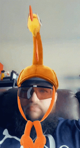 A Man Wearing Sunglasses And A Hat With A Turkey On It GIF
