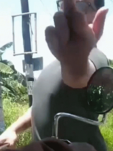 A Man Wearing Sunglasses And A Helmet Giving The Middle Finger GIF