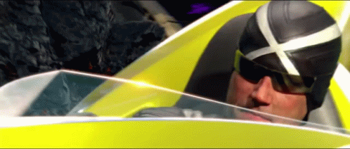 A Man Wearing Sunglasses And A Helmet Is Driving A Yellow Car GIF