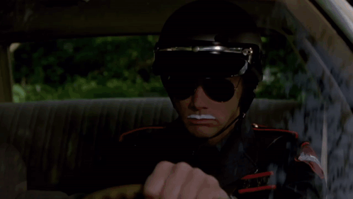 A Man Wearing Sunglasses And A Helmet That Says Amber Island State Police GIF