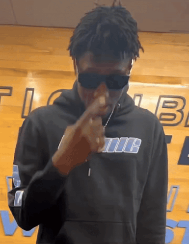 A Man Wearing Sunglasses And A Hoodie That Says Iic GIF