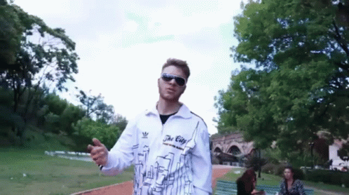 A Man Wearing Sunglasses And A Jacket That Says The City On It GIF