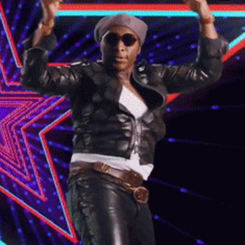A Man Wearing Sunglasses And A Leather Jacket Is Dancing GIF