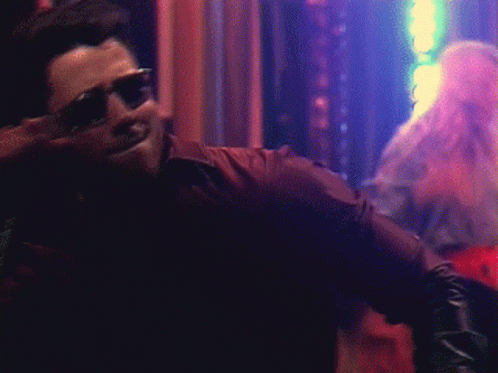 A Man Wearing Sunglasses And A Leather Jacket Is Smiling GIF