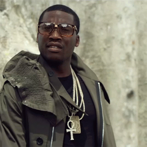 A Man Wearing Sunglasses And A Necklace With A Cross And A 100 Dollar Bill On It GIF