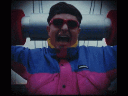 A Man Wearing Sunglasses And A Pink And Blue Jacket GIF