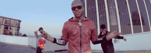 A Man Wearing Sunglasses And A Pink Jacket With A Sleeve That Says ' Ncrb ' On It GIF
