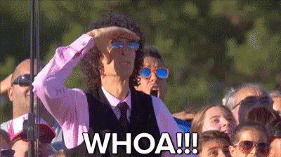 A Man Wearing Sunglasses And A Pink Shirt Is Standing In Front Of A Crowd And Says Whoa . GIF
