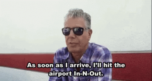 A Man Wearing Sunglasses And A Plaid Shirt Is Sitting On A Bench And Talking . GIF