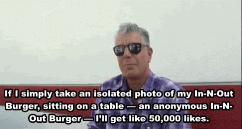 A Man Wearing Sunglasses And A Purple Shirt Is Sitting On A Table And Talking About A Burger GIF