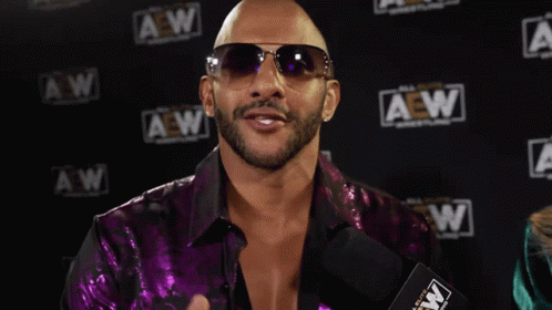 A Man Wearing Sunglasses And A Purple Shirt Says " It 'S About Damn Time " GIF