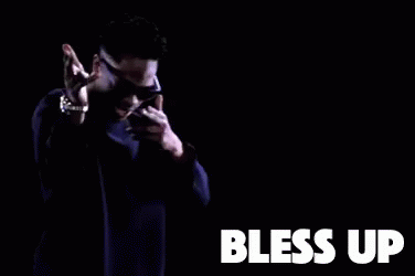 A Man Wearing Sunglasses And A Purple Sweater Is Dancing In A Dark Room With The Words Bless Up . GIF