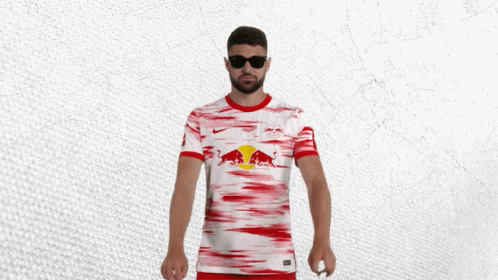 a man wearing sunglasses and a red and white shirt with a red bull on it