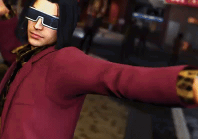 A Man Wearing Sunglasses And A Red Jacket Is Standing In A Street . GIF