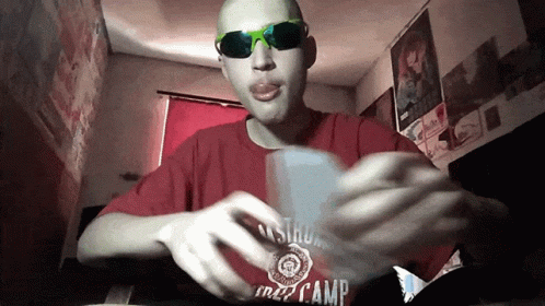 A Man Wearing Sunglasses And A Red Shirt That Says Camp On It GIF