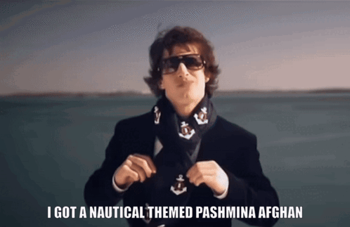 A Man Wearing Sunglasses And A Scarf Has The Words I Got A Nautical Themed Pashmina Afghan On The Bottom GIF