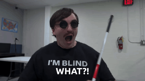 A Man Wearing Sunglasses And A Shirt That Says " I 'M Blind What " GIF