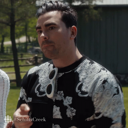 A Man Wearing Sunglasses And A Shirt That Says Schitts Creek On The Bottom GIF