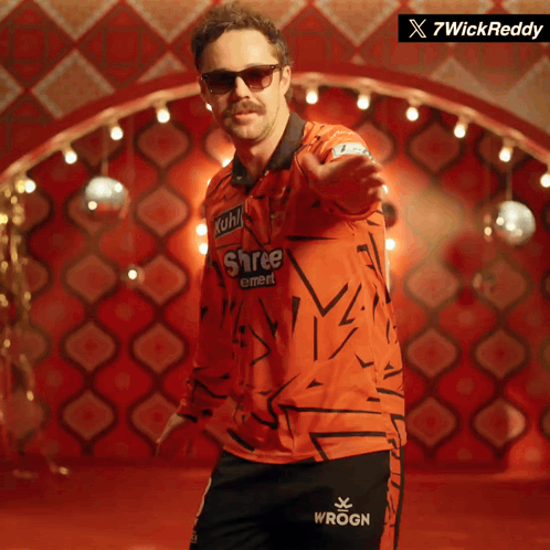 A Man Wearing Sunglasses And A Shree Cement Shirt GIF