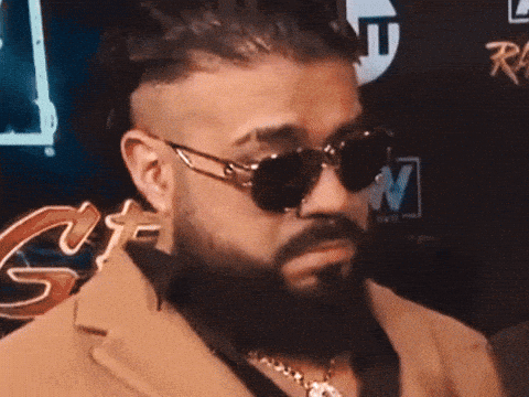 A Man Wearing Sunglasses And A Suit Is Being Interviewed By A Man Holding A Microphone That Says Tnt GIF