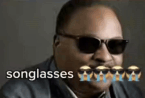 A Man Wearing Sunglasses And A Suit With The Words Songglasses Written On It . GIF