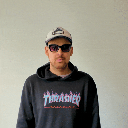 A Man Wearing Sunglasses And A Thrasher Magazine Sweatshirt GIF