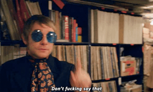 A Man Wearing Sunglasses And A Tie Is Standing In Front Of A Bookshelf And Says `` Don 'T Fucking Say That '' GIF