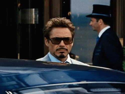 A Man Wearing Sunglasses And A Top Hat Is Looking Out Of A Car Window GIF