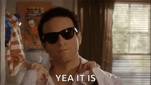 A Man Wearing Sunglasses And A White Shirt Is Adjusting His Shirt And Says `` Yea It Is '' . GIF