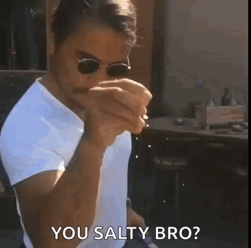 A Man Wearing Sunglasses And A White Shirt Is Holding A Cigarette In His Mouth And Says `` You Salty Bro '' . GIF