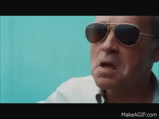 A Man Wearing Sunglasses And A White Shirt Is Making A Funny Face GIF