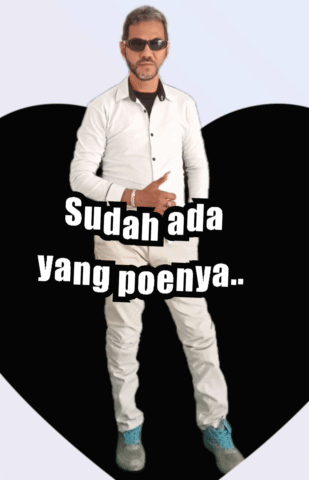 A Man Wearing Sunglasses And A White Shirt Is Standing In Front Of A Heart That Says Sudah Ada Yang Poenya GIF
