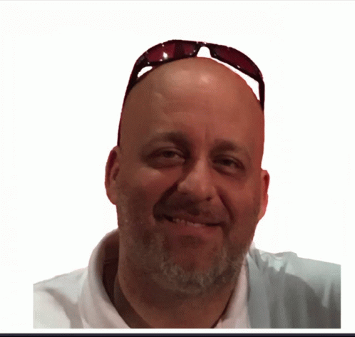 A Man Wearing Sunglasses And A White Shirt Smiles For The Camera GIF