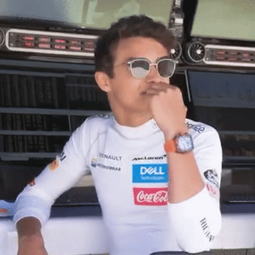 A Man Wearing Sunglasses And A White Shirt With A Dell And Coca Cola Logo On It Is Sitting In A Garage . GIF