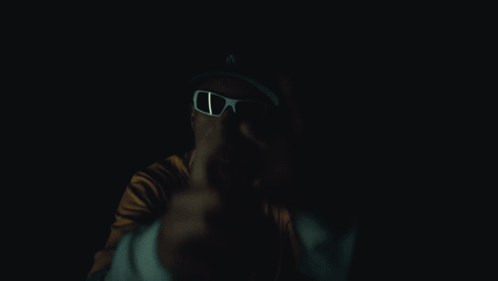 A Man Wearing Sunglasses And A Yellow Shirt With Bape On It GIF