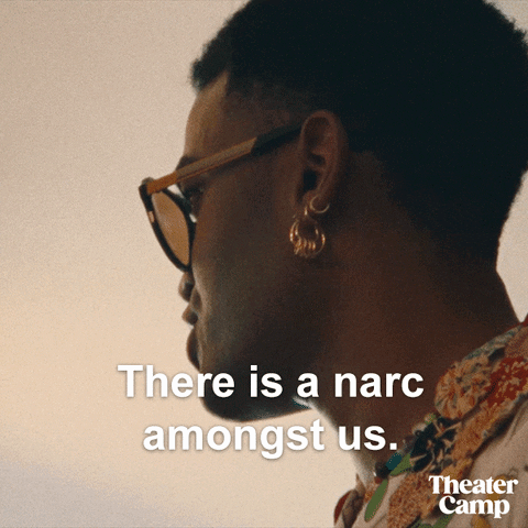 A Man Wearing Sunglasses And Earrings Says There Is A Narciss Amongst Us GIF