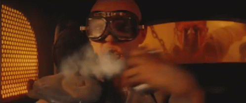 A Man Wearing Sunglasses And Goggles Is Smoking A Cigarette . GIF