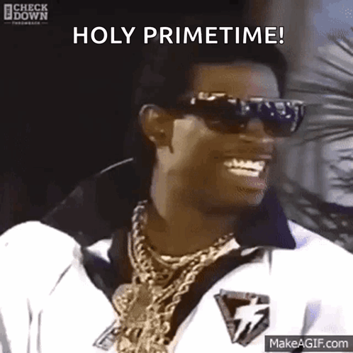 A Man Wearing Sunglasses And Gold Chains Is Smiling And Saying Holy Primetime GIF